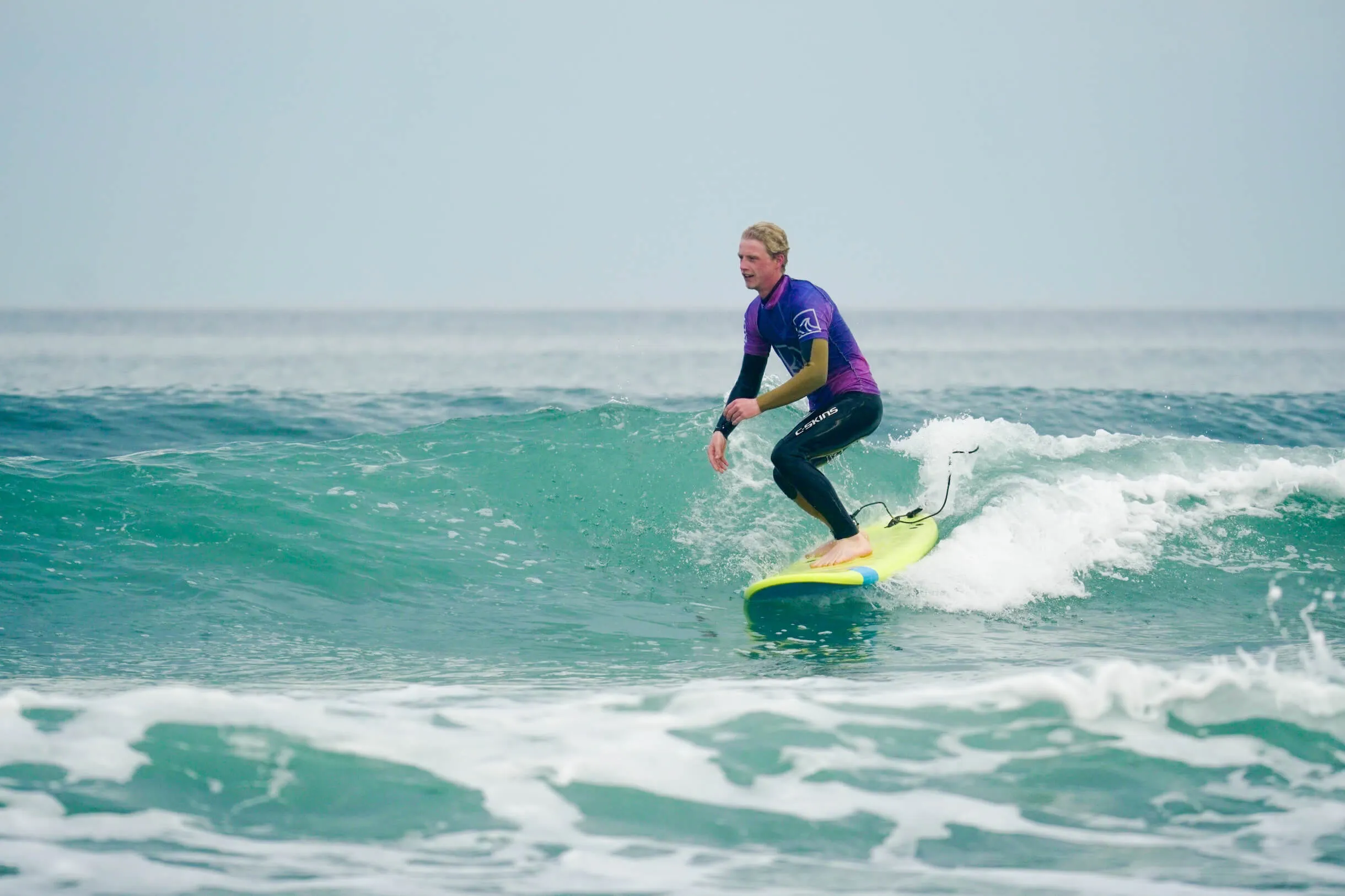Surfer riding a wave in Widemouth Bay on a Surf lesson with OA Surf Club